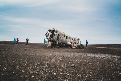 Abandoned airplane on land against sky