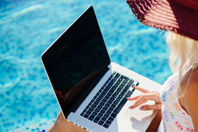 Midsection of woman using laptop on table