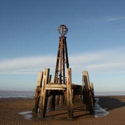 Lifeguard hut on beach against sky