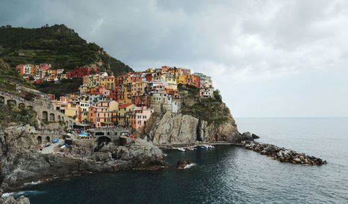 Scenic view of sea by buildings against sky