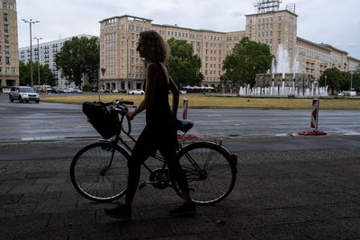 Woman riding bicycle on street in city