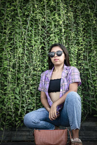 Young woman wearing sunglasses sitting outdoors