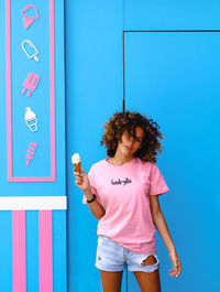 Woman standing against blue wall