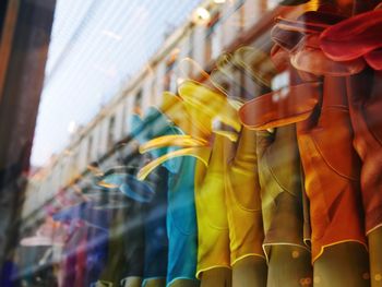 Low angle view of multi colored gloves hanging on street