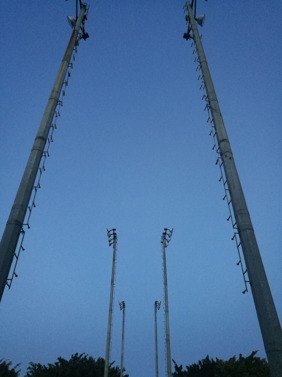 LOW ANGLE VIEW OF COMMUNICATIONS TOWER AGAINST BLUE SKY