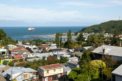 High angle view of town by sea against sky