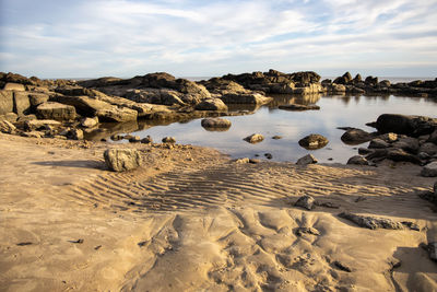 Rocks on beach against sky