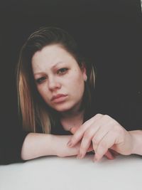 Close-up of beautiful young woman over black background