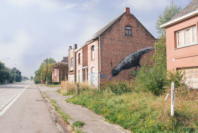 Footpath amidst buildings against sky