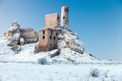 Old damaged building against clear blue sky