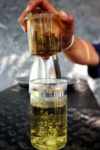 Close-up of hand pouring wine in glass