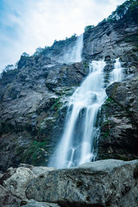 Waterfall white water stream falling from mountains at day from flat angle