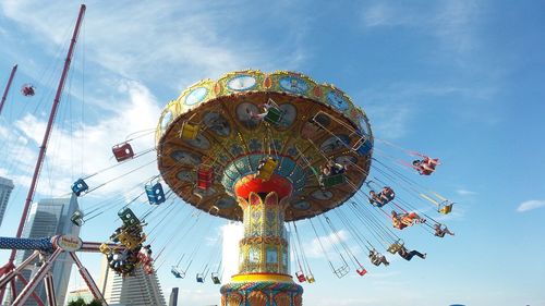 Low angle view of chain swing ride against sky