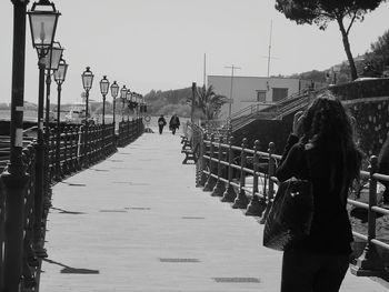 Rear view of people walking on footpath