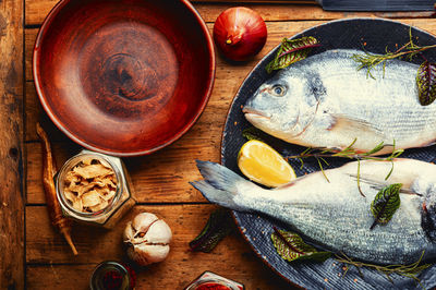 Two raw dorado fish for cooking on a plate.