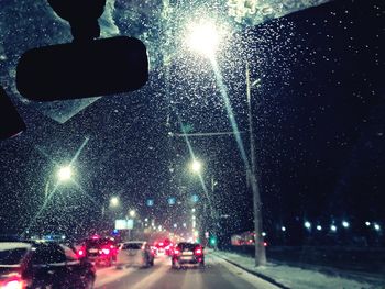 Illuminated street lights seen through wet glass