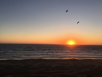 Scenic view of beach and sea against sky during sunset 