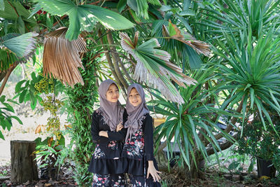Cute asian muslim girls wearing hijab fashion with green tree in rural scene