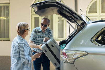 Side view of man using mobile phone in car