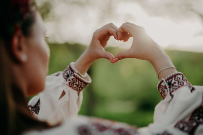 Cropped hands of woman holding wedding dress