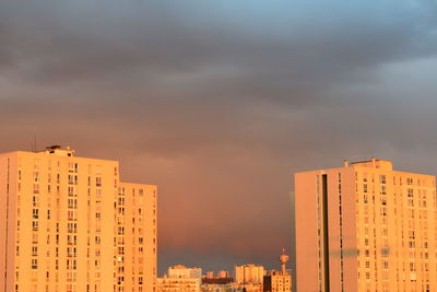 Buildings against cloudy sky at sunset