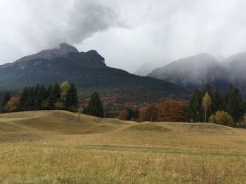 Scenic view of green landscape and mountains against sky