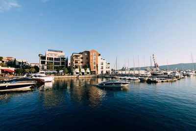 Boats in sea against clear blue sky