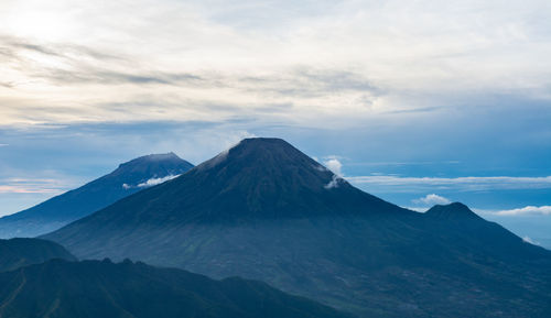 Scenic view of snowcapped mountains against cloudy sky