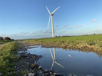 Windmill on field against sky