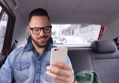 Mid adult man using mobile phone while sitting in bus