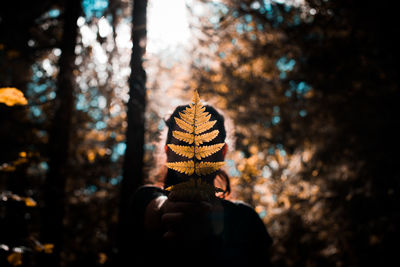 Portrait of person holding umbrella against trees in forest