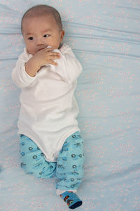 Cute baby girl on bed at home