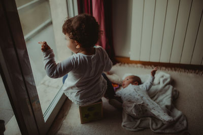 Baby siblings sitting at home