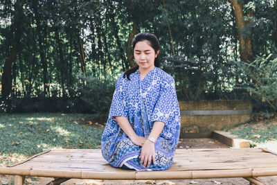 Woman with scarf sitting on bench outdoors