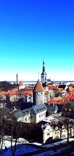 View of buildings in town against blue sky