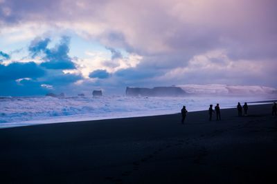 People on beach against sky