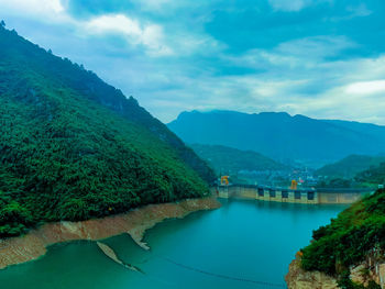 Scenic view of river and mountains against sky