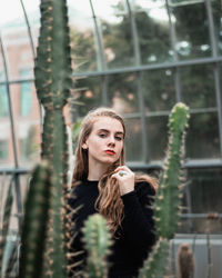 Portrait of young woman against building