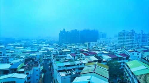 Aerial view of cityscape during winter against blue sky