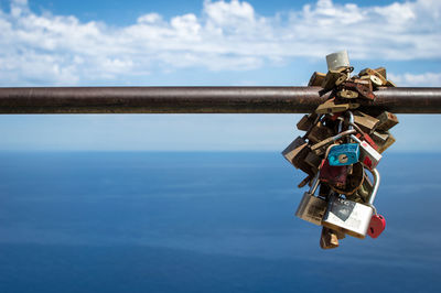 Close-up of padlocks on railing against sea