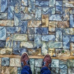 Low section of man standing on cobblestone