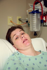 Portrait of mid adult woman lying on hospital bed