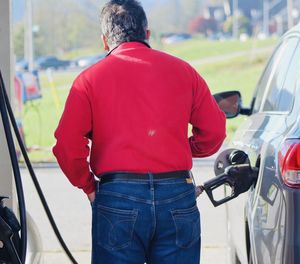 Rear view of man standing in car