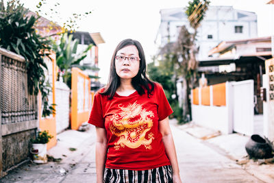 Portrait of young woman standing in city