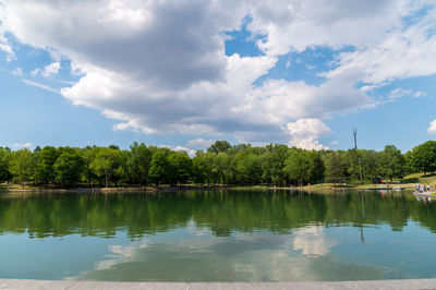 Scenic view of lake by trees against sky