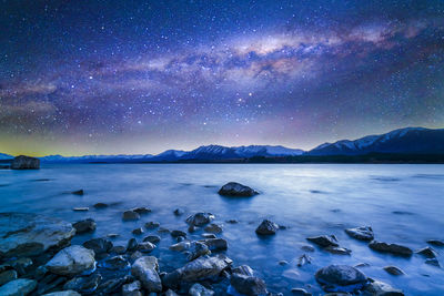 Scenic view of lake against sky at night