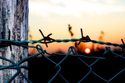 Close-up of barbed wire against sky