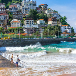 People on beach by buildings in city