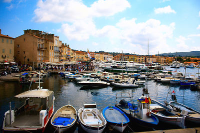 Boats moored at harbor by buildings in city