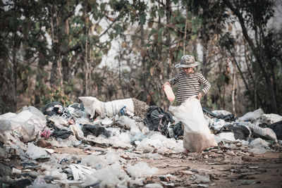 Rear view of garbage against trees in forest